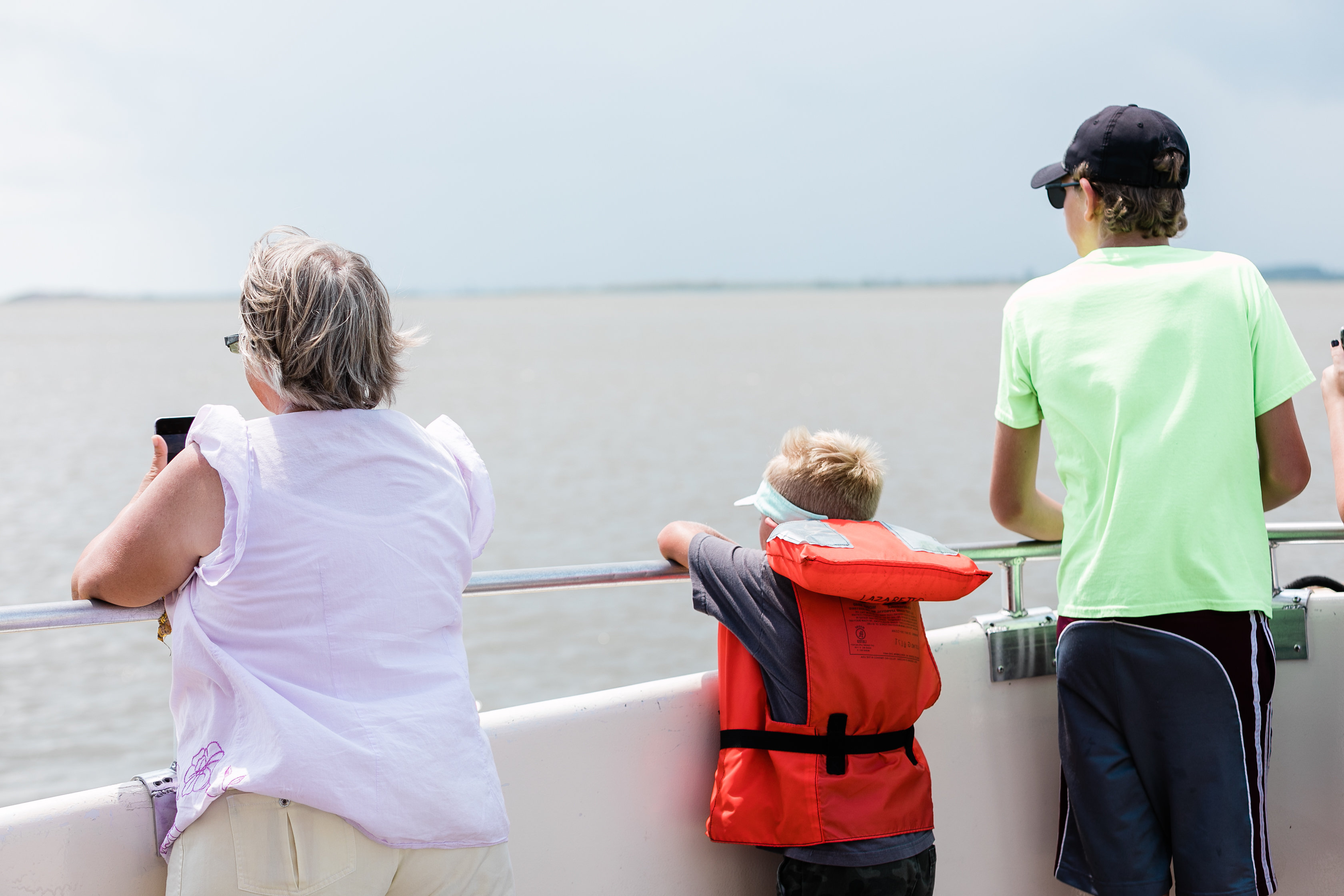 People dolphin watching on a boat.