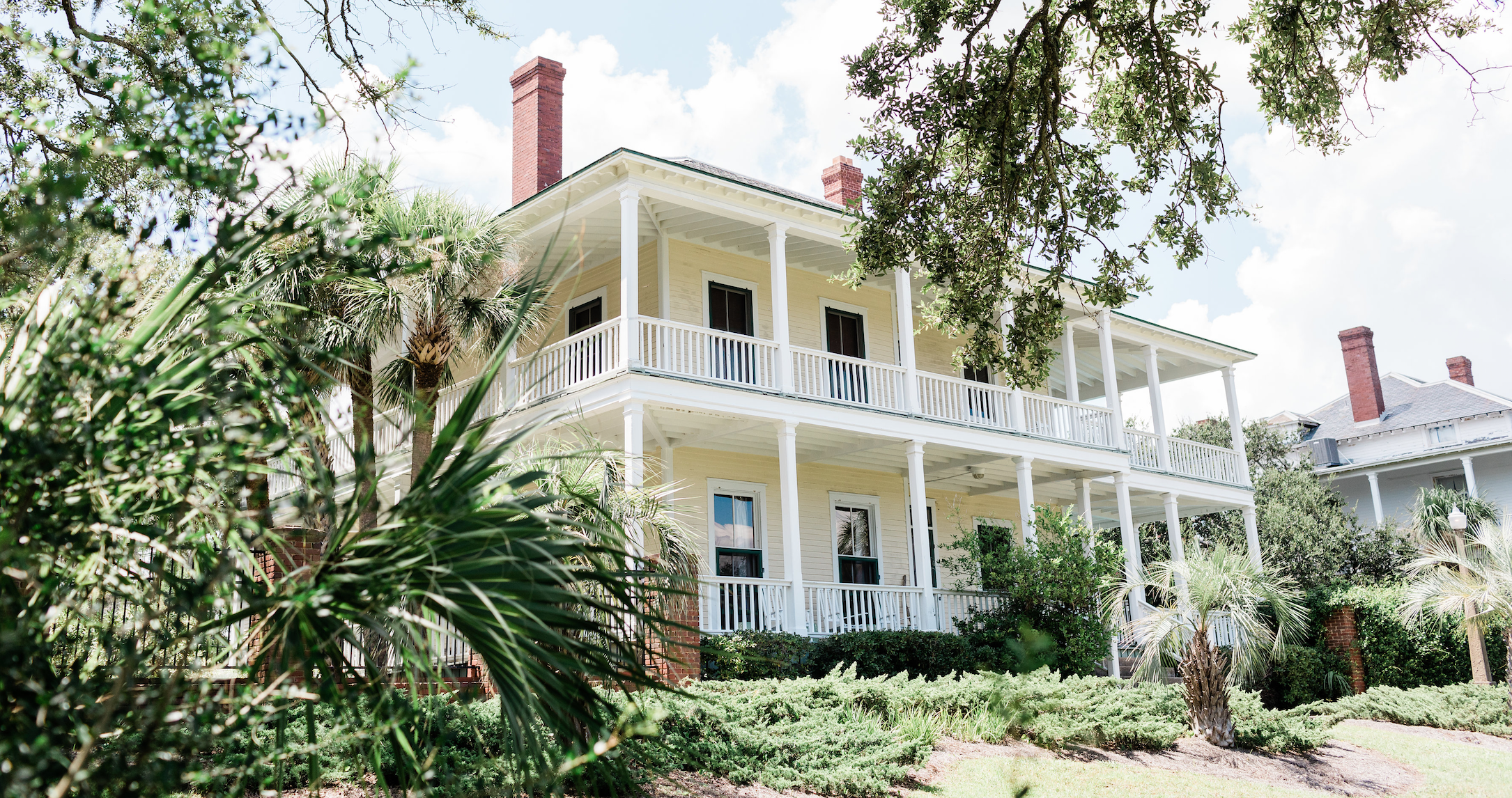 An exterior view of a large beach mansion.