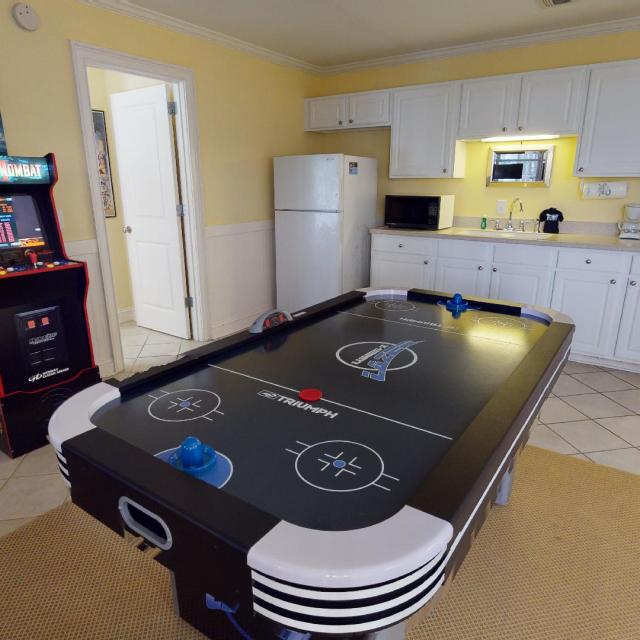 Kitchenette with gaming table and arcade game