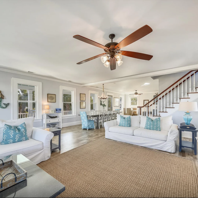 Spacious living and dining area with ample seating, TV and view of staircase