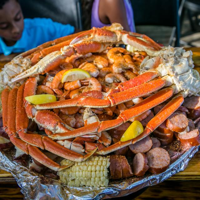 A shareable plate of crab legs, shrimp, corn on the cob and sausage.