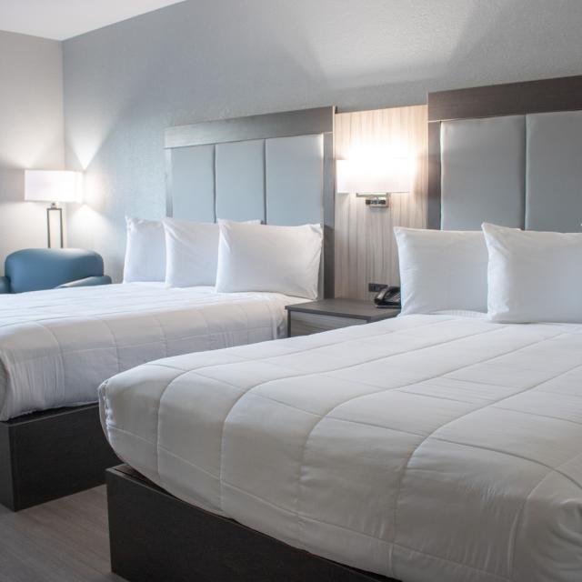 Double queen hotel room with white bedding