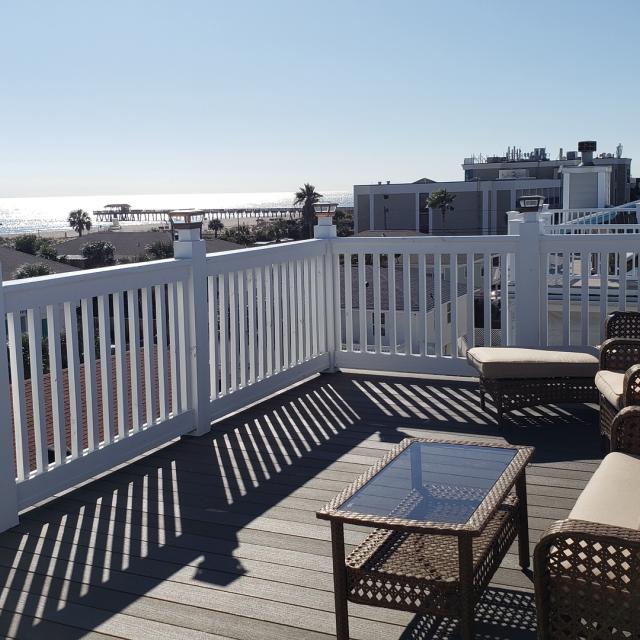 An outdoor balcony with ample seating and ocean views