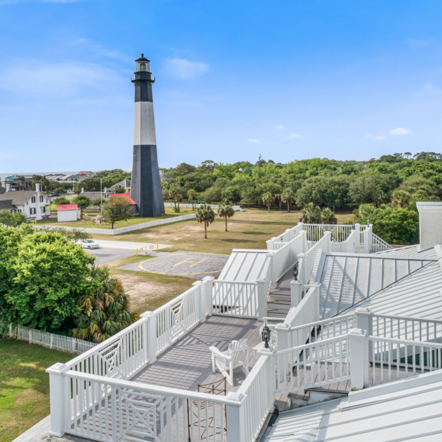 An outdoor rooftop deck with a view of a lighthouse.