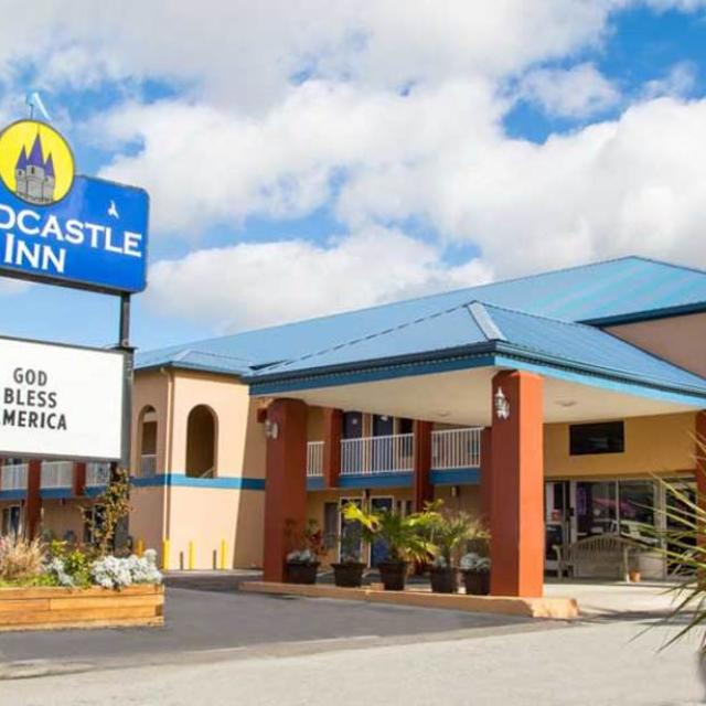The exterior view of a hotel sign and its front entrance.