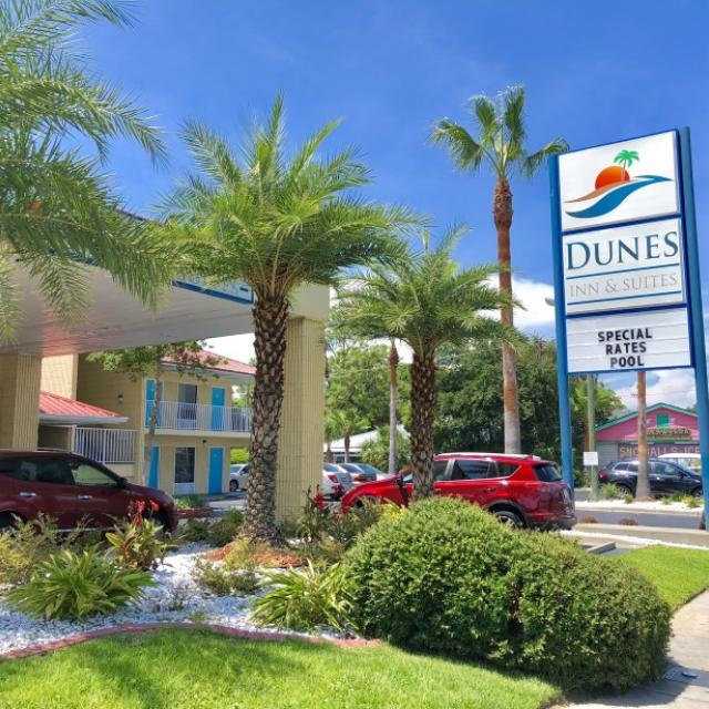 The exterior front view of a hotel and its sign.