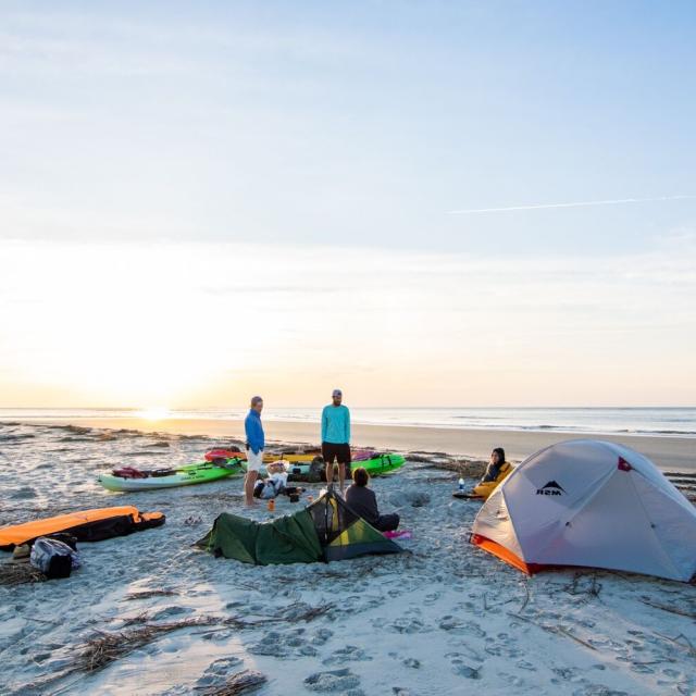 People camping on Little Tybee Island at sunset.