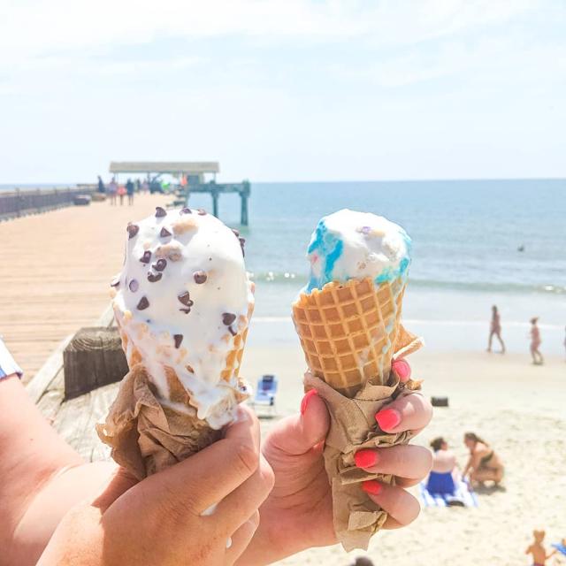 Two ice creams with the beach in the background.