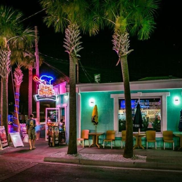 A restaurant and bar at night with neon lights.