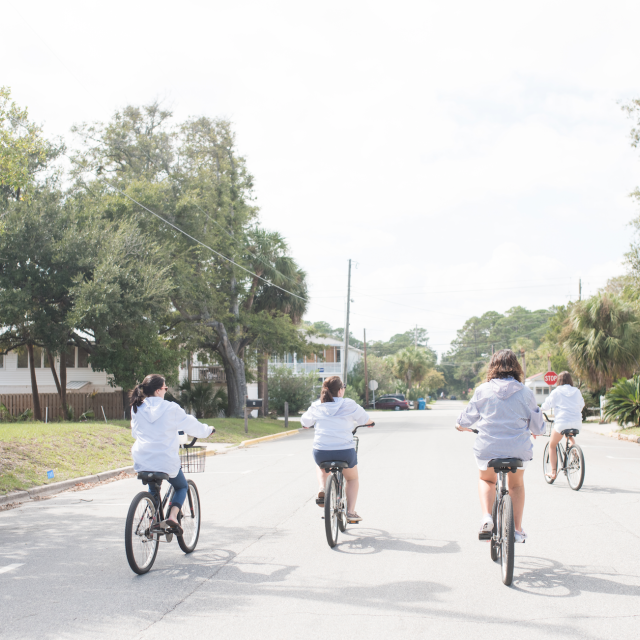 A group of five women riding bikes.