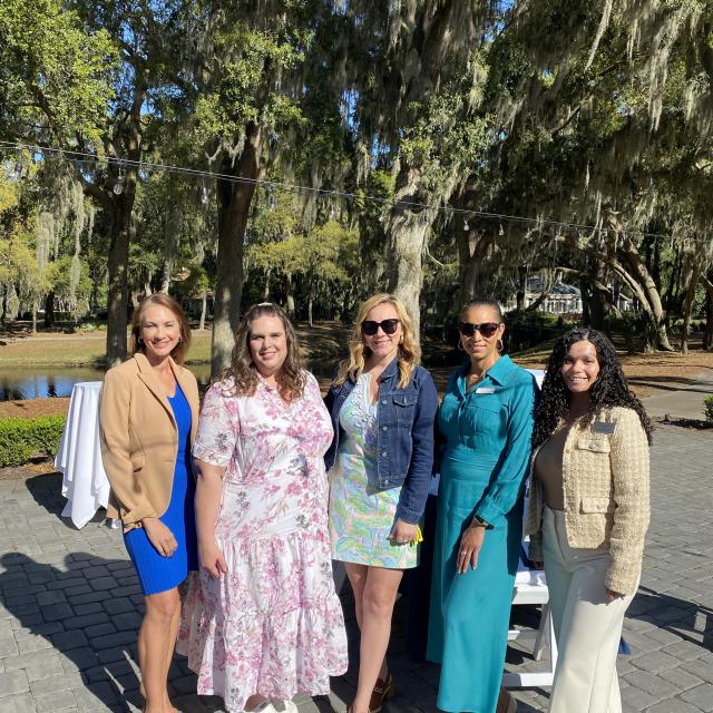 Five ladies posing for a photo outside