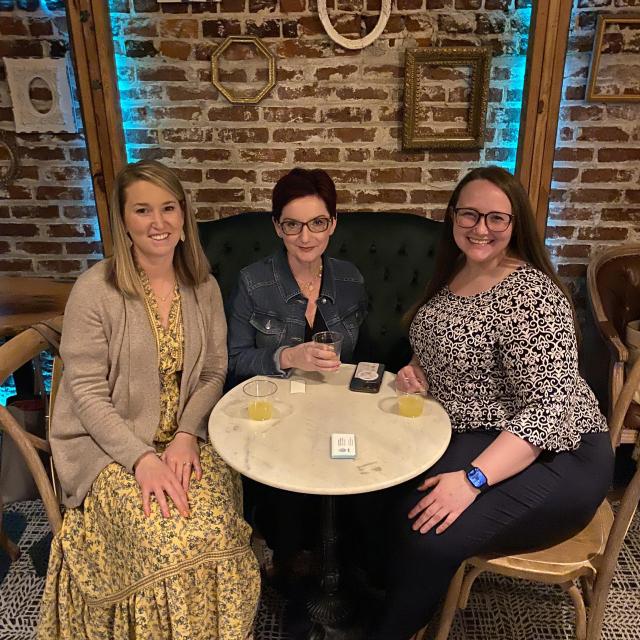 Three ladies sitting at an indoor table
