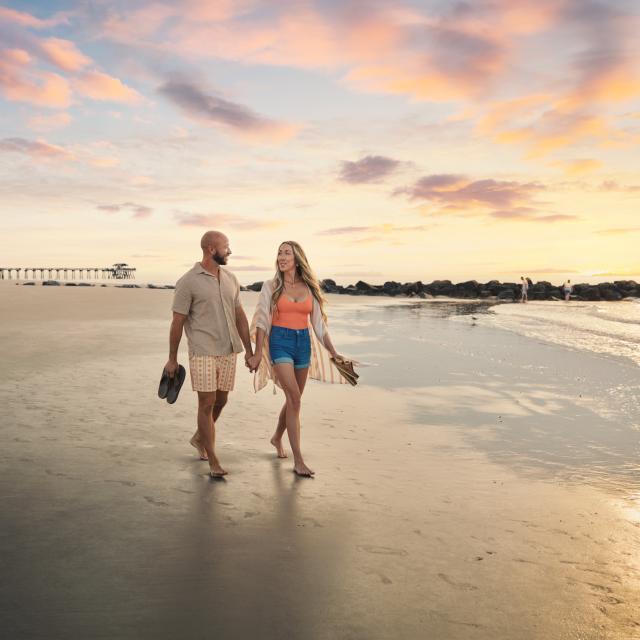couple walking at sunrise along south beach