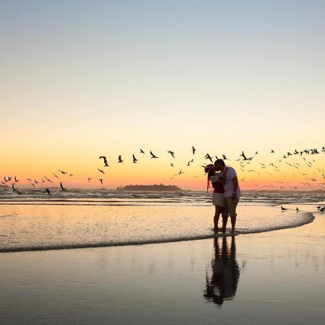 Couple kissing on the beach at sunset