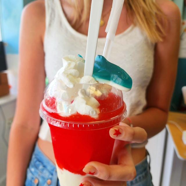 A woman holding a cold sweet drink.