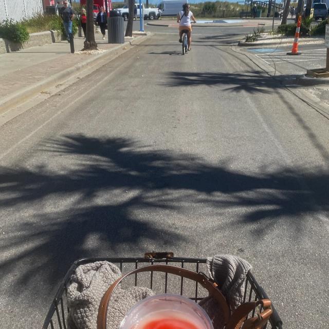 Bike riding with a cold drink in the handle basket.