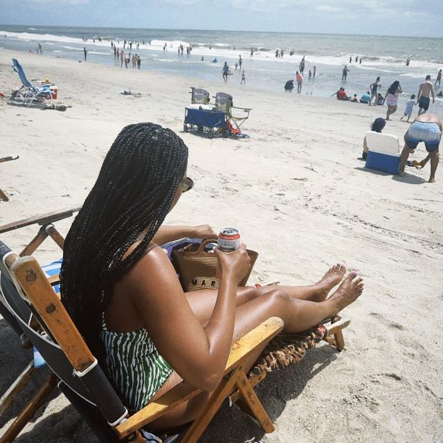A woman sitting in a beach chair on the beach.