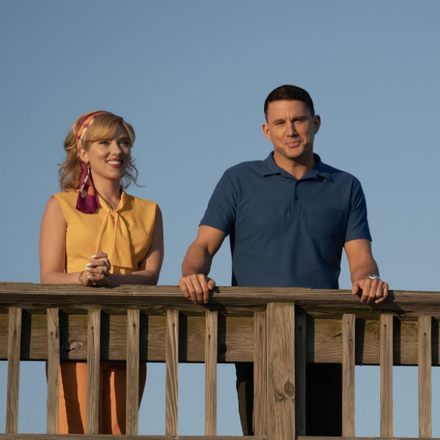 A man and woman standing on a beach pier.
