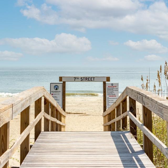 A wooden boardwalk that leads to the beach.