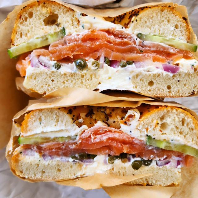 A loaded bagel sandwich cut in half.