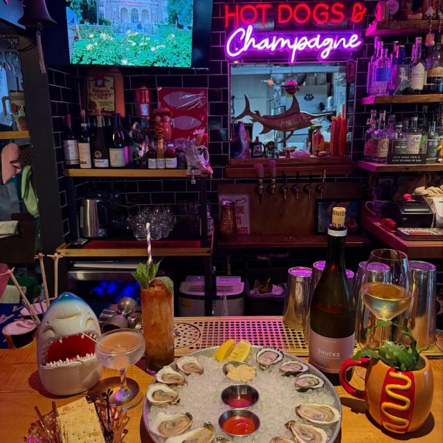 A serving of oysters and champagne sitting on a bar.