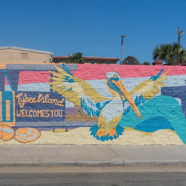 A colorful welcome sign mural with a pelican that reads: Welcome to Tybee Island.