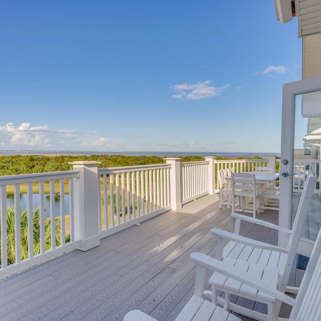 An expansive outdoor balcony overlooking marshland and a dock.