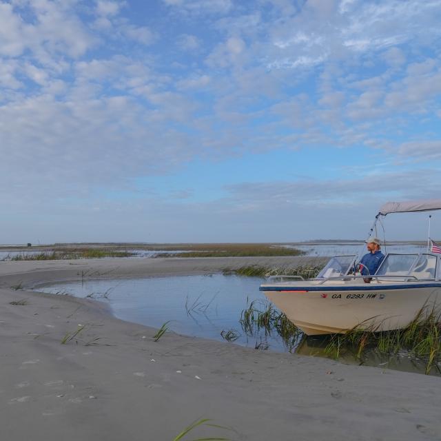 A boat captain sitting in a boat on the water of Tybee Island, GA.