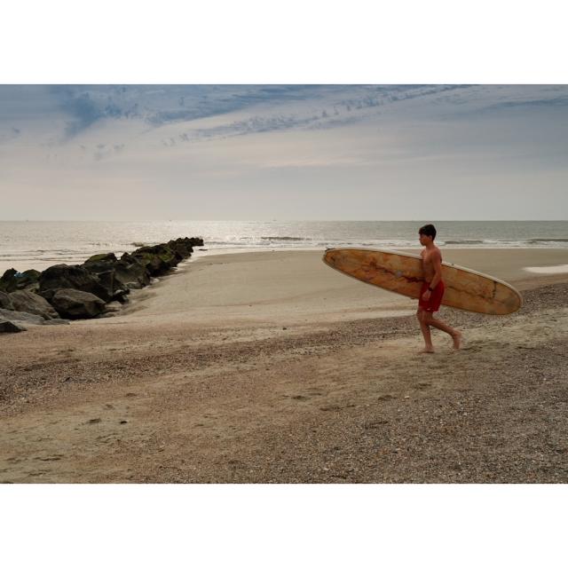 A young surfer heading towards the ocean on Tybee Island, GA.