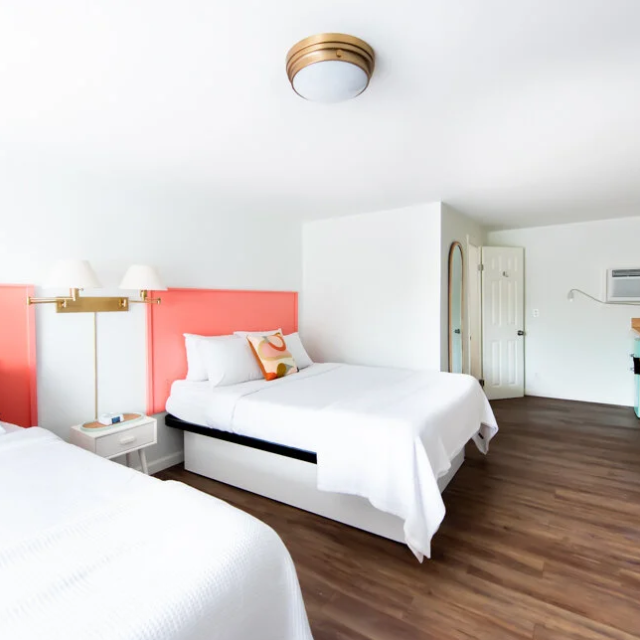 A spacious motel room with two queen beds.