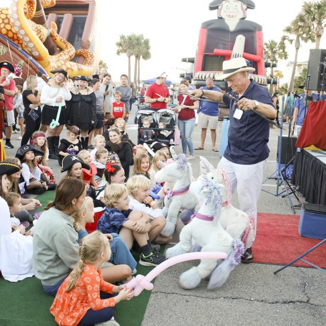 Kids being entertained with puppets at a carnival.