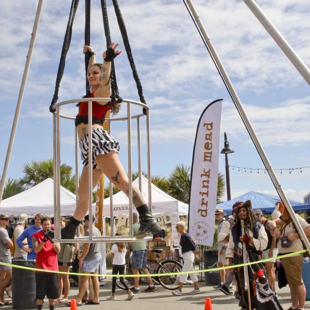 A woman performing aerial acts outdoors at a carnival.