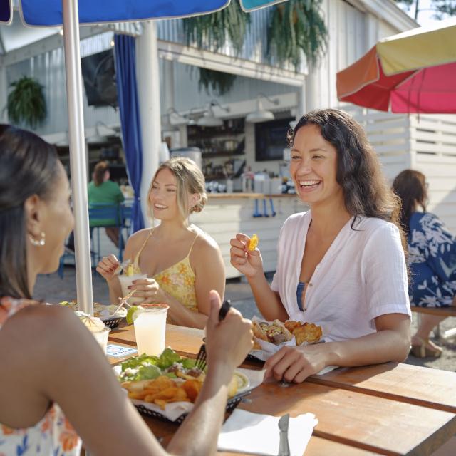 A group of friends enjoying a restaurant meal in an outdoor setting.