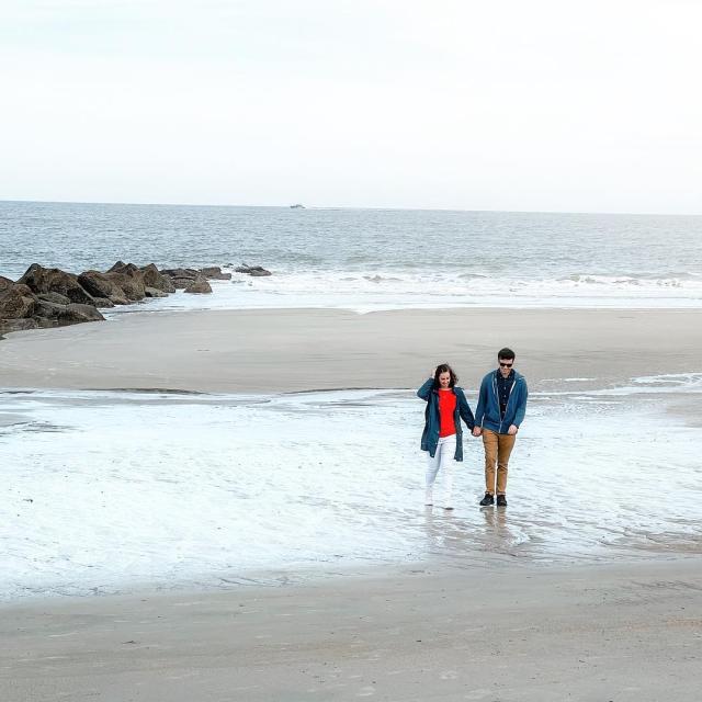 A couple walking the beach on Tybee Island, GA during winter.