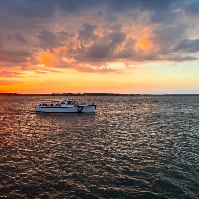 A boat in the water at sunset.