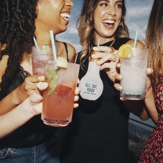 A group of friend girls enjoying drinks at Electric Moon Skytop Lounge.