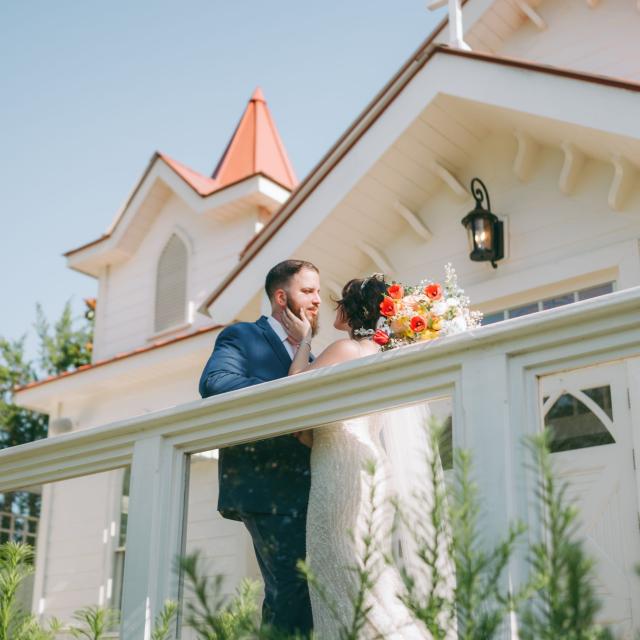 Bride and groom embrace on the porch of The Chapel by the Sea on Tybee Island.