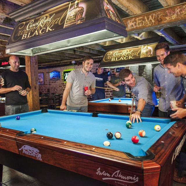 A group of men shooting pool.
