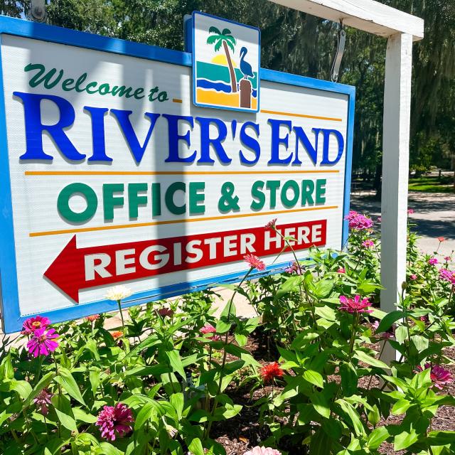 River’s End Campground office and store sign surrounded by colorful flowers.