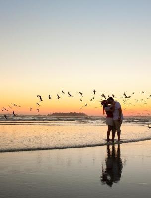 Couple kissing on the beach at sunset