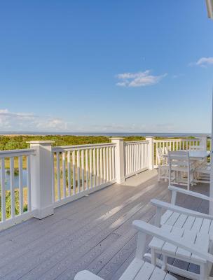 An expansive outdoor balcony overlooking marshland and a dock.