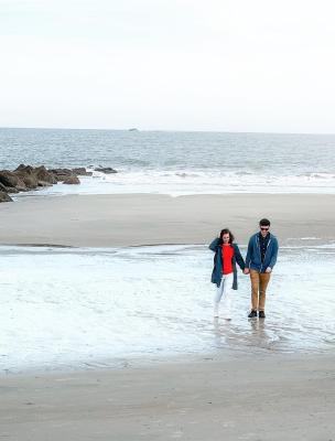 A couple walking the beach on Tybee Island, GA during winter.