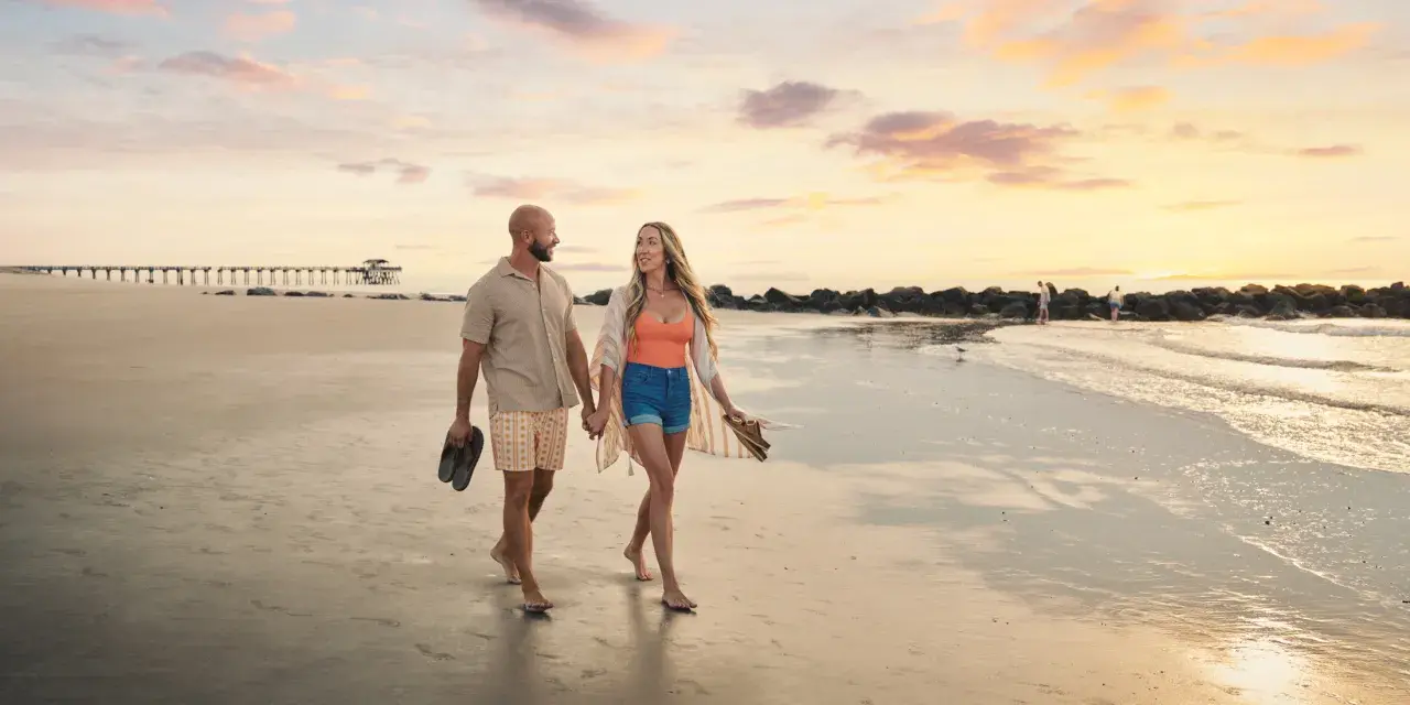 couple walking at sunrise along south beach