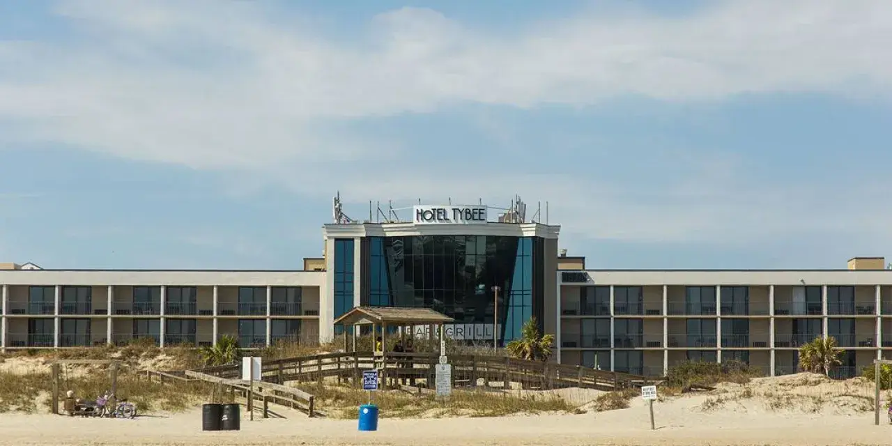 The front exterior view of a hotel on the beach.