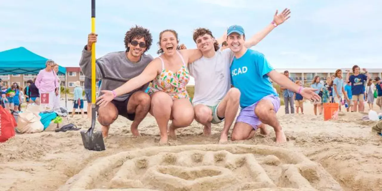 A group of people creating art out of sand.