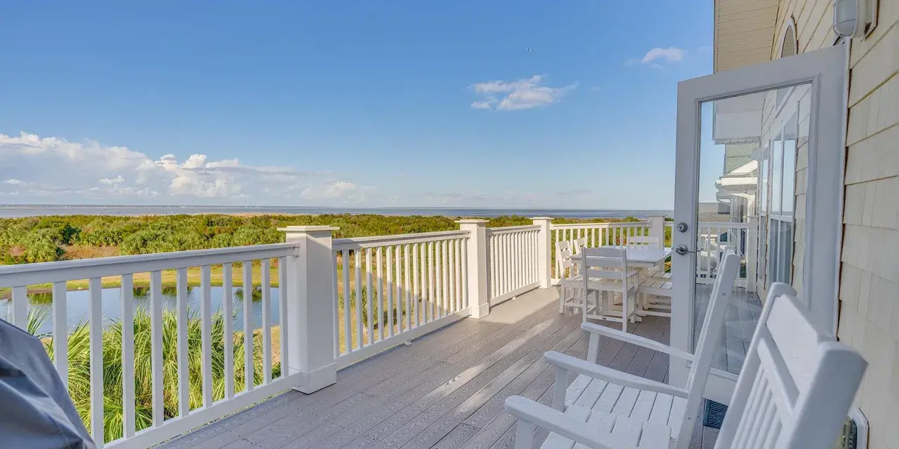 An expansive outdoor balcony overlooking marshland and a dock.