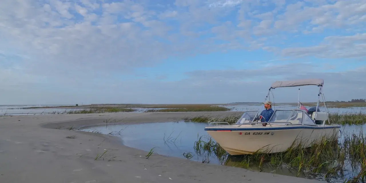 A boat captain sitting in a boat on the water of Tybee Island, GA.