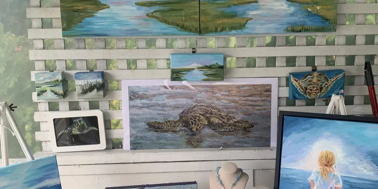 A variety of paintings and handmade jewelry available for purchase in an art gallery.