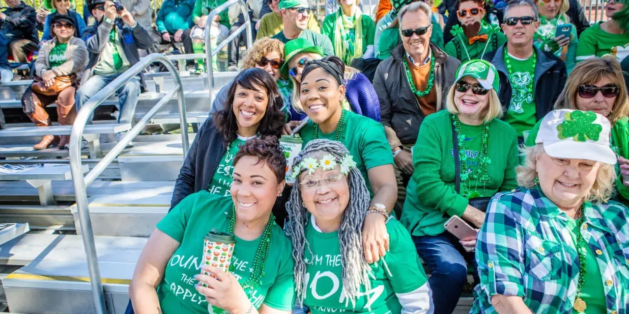Savannah St. Patrick’s Day parade goers sitting on bleachers.