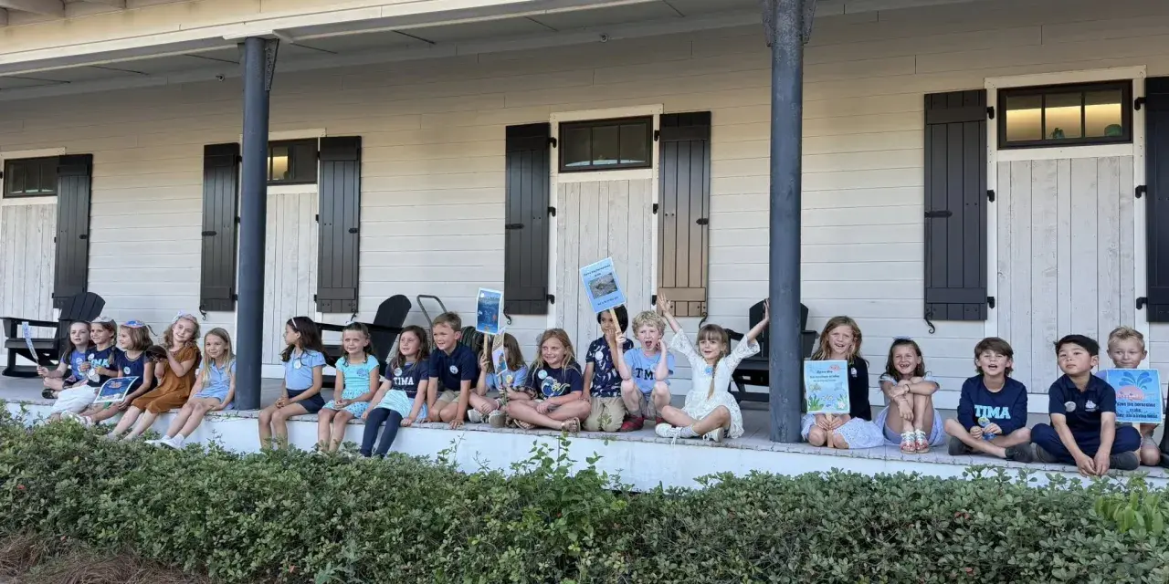 Grade school kids posing for a photo outdoors.